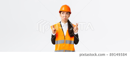 Sad nervous and unconfident asian female construction manager in safety helmet, pouting and look in panic upper left corner, making wish, cross fingers good luck, pleading over white background Sad nervous and unconfident asian female construction manager in safety helmet, pouting and look in panic upper left corner, making wish, cross fingers good luck, pleading over white background 89149384
