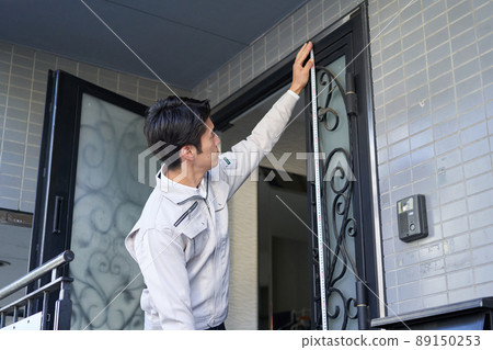 A man in a construction shop who measures dimensions 89150253