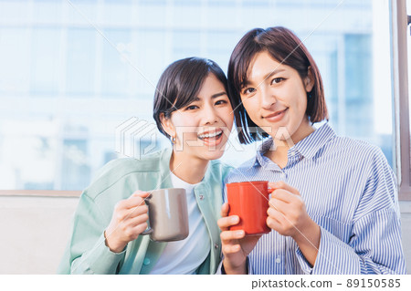 Two women holding a cup (image of a female partner) 89150585