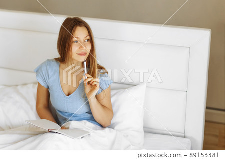 Mental health care, positive thinking and wellness concept. Woman lying in bed, practicing stress relief challenge with journal about feeling and gratitude list, focus on word mental. 89153381
