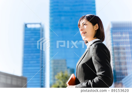 一個拿著筆記本望遠方的女人 89153620