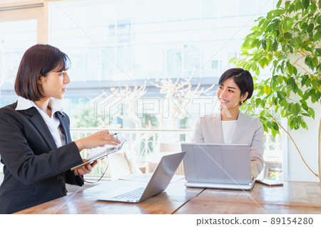 Two women consulting and working Two women consulting and working 89154280
