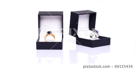 Gold ring with blue sapphire and diamond in dark blue jewel box. The platinum ring was placed next to it. Collection of natural gemstones accessories. Studio shot Gold ring with blue sapphire and diamond in dark blue jewel box. The platinum ring was placed next to it. Collection of natural gemstones accessories. Studio shot 89155434