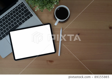Comfortable workplace with digital tablet, laptop computer and coffee cup on wooden background. Top view. 89155865