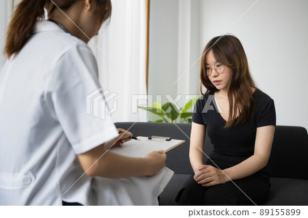 Rear view of professional psychologist consulting in psychotherapy session with patient in clinic. Rear view of professional psychologist consulting in psychotherapy session with patient in clinic. 89155899