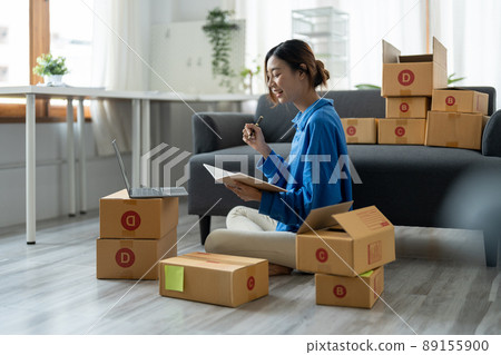 Sell online, Young asian woman checking order and customer's details and addresses on laptop or box in order to prepare for shipping according to the information, Online shopping SME entrepreneur Sell online, Young asian woman checking order and customer's details and addresses on laptop or box in order to prepare for shipping according to the information, Online shopping SME entrepreneur 89155900