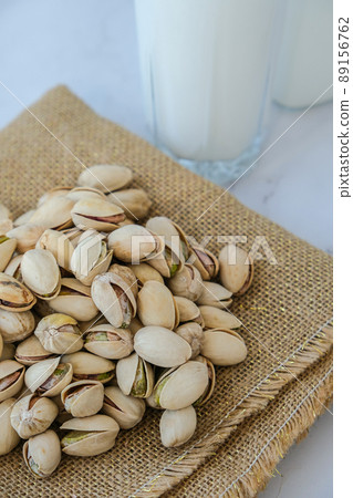 Pistachio lactose free milk for dietary nutrition. Alternative food and vegetarianism. Glass of healthy pistachio milk stands on concrete background. Diet milk, vegetarian food. Gluten free. Pistachio lactose free milk for dietary nutrition. Alternative food and vegetarianism. Glass of healthy pistachio milk stands on concrete background. Diet milk, vegetarian food. Gluten free. 89156762