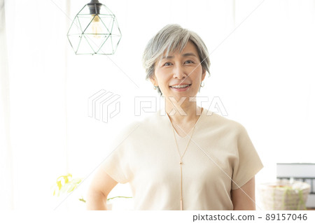 A woman in her 50s with a lovely smile on her gray hair 89157046
