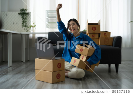 Attractive Asian woman online working in office desk use laptop computer, online marketing packaging box delivery, SME e-commerce concept 89157116
