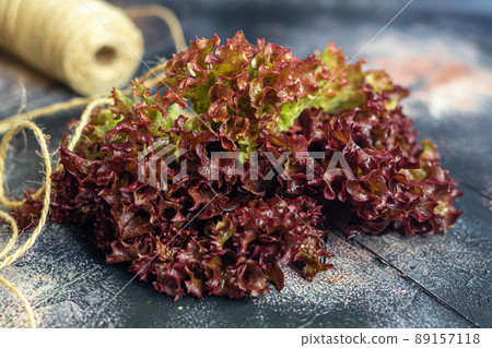 Leaves of green and red lettuce. Spring harvest, benefits and vitamins. On a dark background. 89157118
