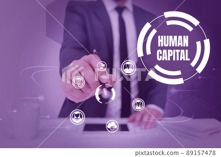 Conceptual caption Human Capital. Concept meaning Intangible Collective Resources Competence Capital Education Businessman in suit holding pen symbolizing successful teamwork. Conceptual caption Human Capital. Concept meaning Intangible Collective Resources Competence Capital Education Businessman in suit holding pen symbolizing successful teamwork. 89157478
