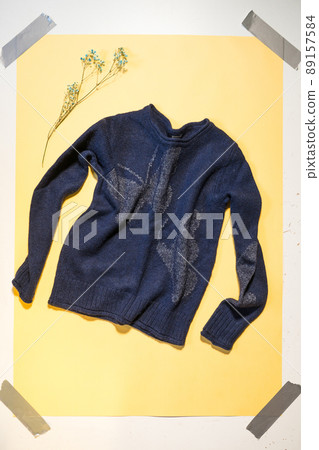 blue women's sweater on yellow background top view 89157584