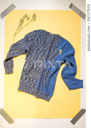 blue women's sweater lies on yellow background blue women's sweater lies on yellow background 89157628