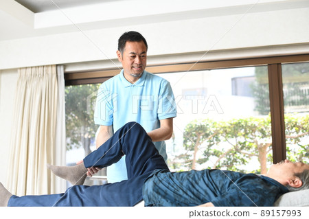 Male chiropractor doing leg manipulative massage 89157993