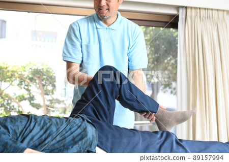 Male chiropractor doing leg manipulative massage 89157994