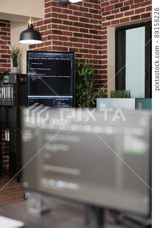 Interior of empty data center office with multiple computer screens showing programming line codes. Server room with modern brick wall interior and high quality hardware and software technology. Interior of empty data center office with multiple computer screens showing programming line codes. Server room with modern brick wall interior and high quality hardware and software technology. 89158226