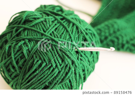 green cotton yarn ball and crochet needle 89158476