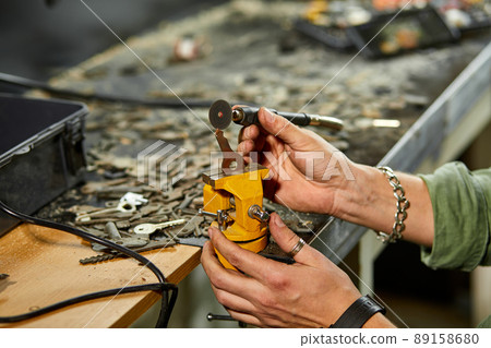 Locksmith in workshop makes new key, use grinding engraving machine 89158680