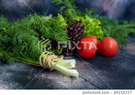 Fresh vegetables for salad. Tomatoes and lettuce, cucumbers with zucchini and cabbage with dill. Spring harvest, benefits and vitamins. On a dark background. Fresh vegetables for salad. Tomatoes and lettuce, cucumbers with zucchini and cabbage with dill. Spring harvest, benefits and vitamins. On a dark background. 89158727