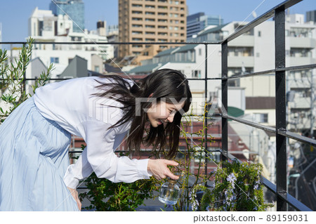 Woman spraying water on plants 89159031