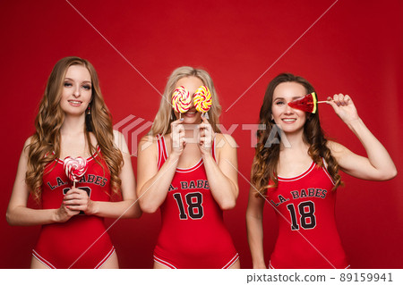 Beautiful and happy female friends in bright red 89159941