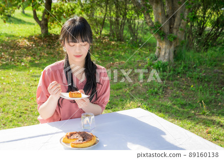Woman eating homemade cheesecake outdoors 89160138
