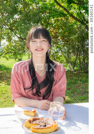 Woman eating homemade cheesecake outdoors 89160141