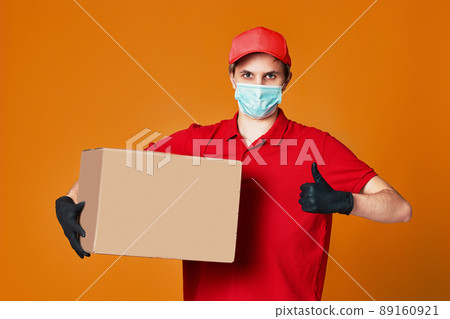 Delivery man employee in red cap face mask, empty cardboard box 89160921