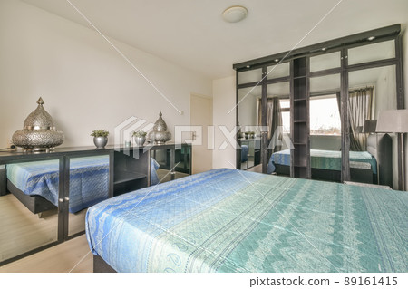 A large double bed with a mirrored cabinet in the spacious bedroom of the house 89161415