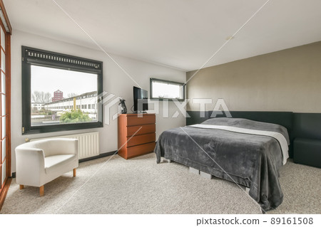 A small bedroom with a TV and a carpet on the floor in a modern house A small bedroom with a TV and a carpet on the floor in a modern house 89161508