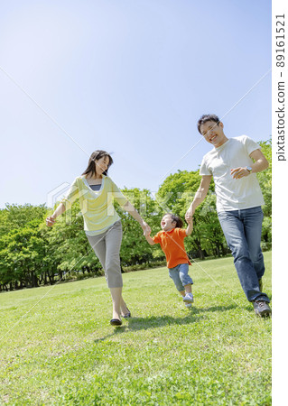 Three families running in a fresh green park 89161521