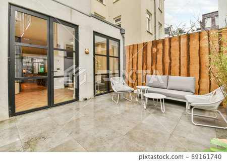 The interior of the backyard with a seating area on the marble floor and the entrance to the apartment The interior of the backyard with a seating area on the marble floor and the entrance to the apartment 89161740
