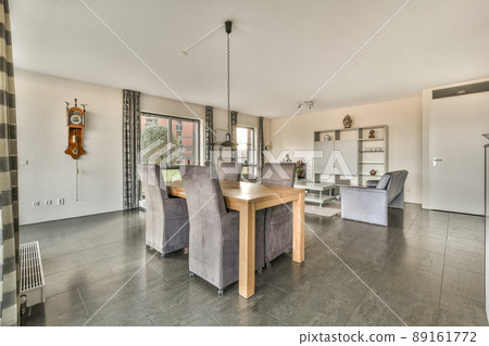 The interior of a spacious living room in an open design with a dining area in a modern house The interior of a spacious living room in an open design with a dining area in a modern house 89161772