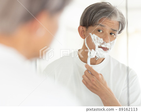 A man in his 50s shaving 89162113