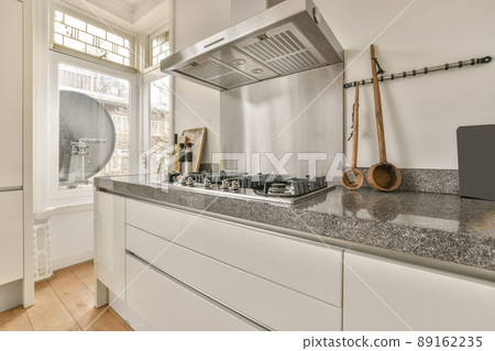 Kitchen with white furniture and marble countertops in a modern house Kitchen with white furniture and marble countertops in a modern house 89162235