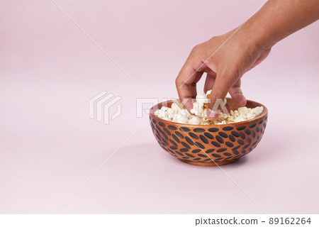 young man picking popcorn from a bowl with copy space  89162264