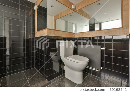 Bathroom interior with black tiles in a modern house with a toilet Bathroom interior with black tiles in a modern house with a toilet 89162341
