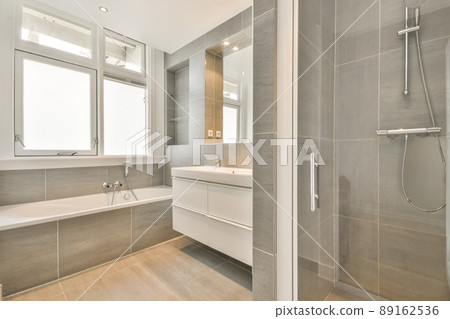 Bathroom in grey design with ceramic bathtub and sink and shower 89162536