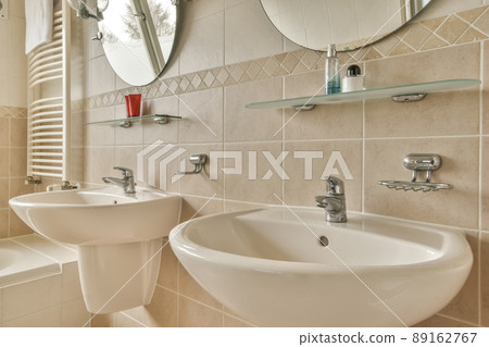 Bathroom interior with beige tiles two sinks and mirrors in a modern house 89162767