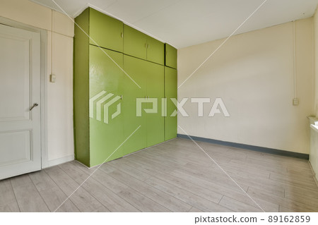 The interior is a minimalist dressing room with large wardrobe and a parquet floor 89162859
