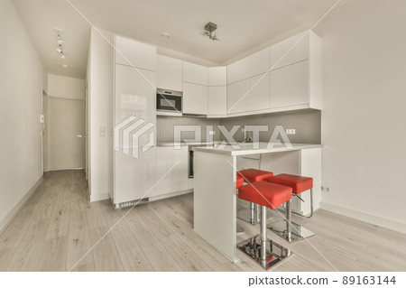 The interior of the apartment is in an open style with a corner kitchen and a dining area in bright colors The interior of the apartment is in an open style with a corner kitchen and a dining area in bright colors 89163144