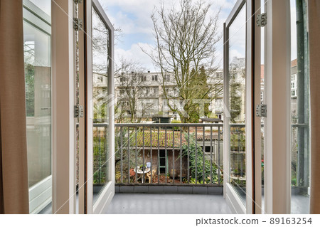 Access to a cozy balcony of a modern house with wooden doors and a metal fence 89163254