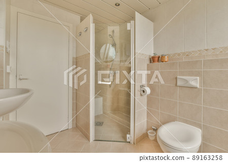 Bathroom interior with beige tiles shower cabin and toilet in a modern house Bathroom interior with beige tiles shower cabin and toilet in a modern house 89163258