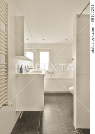The interior of a bathroom decorated with white and black tiles in a modern house with a bathtub shower sink and toilet The interior of a bathroom decorated with white and black tiles in a modern house with a bathtub shower sink and toilet 89163291