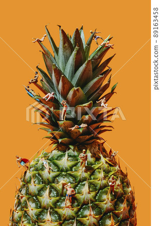 some miniature people in swimsuit on a pineapple some miniature people in swimsuit on a pineapple 89163458