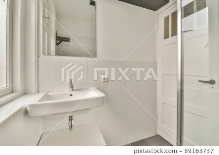 The interior of the bathroom in white of a modern house with sink and mirror 89163737