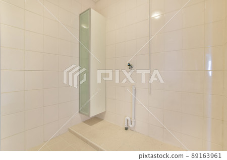 Bathroom interior with ceramic white tiles in the apartment of a cozy house Bathroom interior with ceramic white tiles in the apartment of a cozy house 89163961