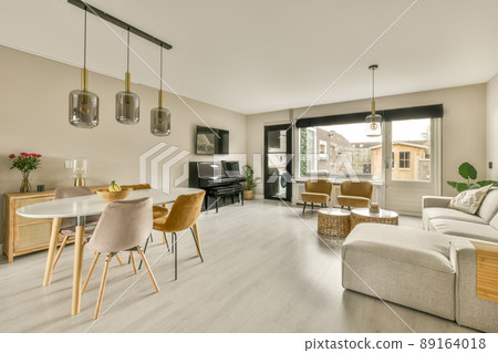 A spacious living room with a dining area in a cozy house with a piano and a TV opposite the sofa 89164018