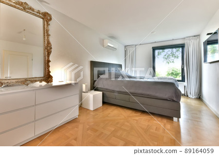 Spacious cozy bedroom with a large bed and a large mirror in a modern apartment 89164059