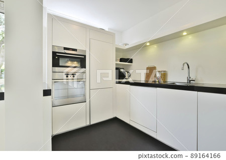 Modernized luxury and compact kitchen with white modern furniture and with all appliances Modernized luxury and compact kitchen with white modern furniture and with all appliances 89164166